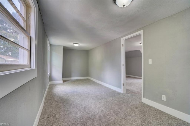 empty room featuring plenty of natural light and light colored carpet