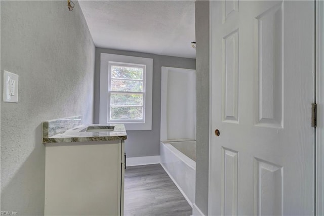 bathroom with hardwood / wood-style flooring, vanity, a textured ceiling, and bathtub / shower combination