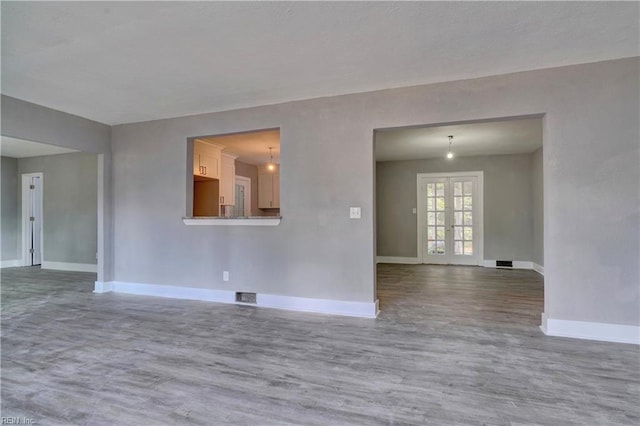 empty room with french doors and wood-type flooring