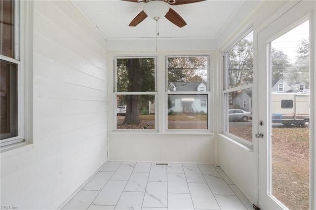 unfurnished sunroom with ceiling fan