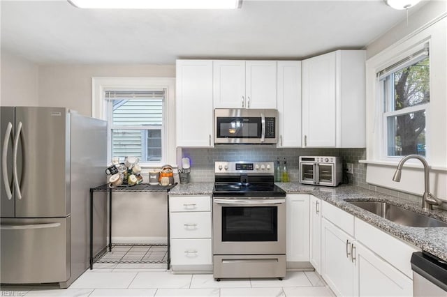 kitchen featuring white cabinets, a healthy amount of sunlight, sink, and stainless steel appliances