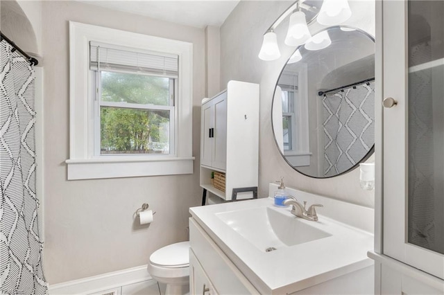 bathroom featuring walk in shower, vanity, and toilet