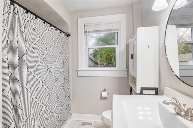 bathroom featuring tile patterned floors, a wealth of natural light, sink, and toilet