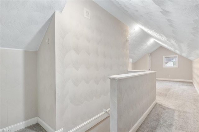 bonus room with carpet flooring and vaulted ceiling