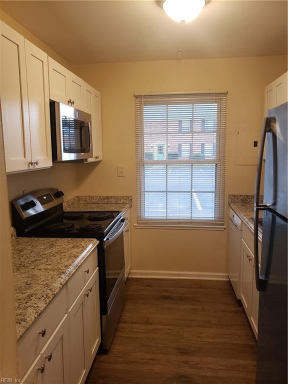 kitchen featuring light stone counters, white cabinetry, dark wood-type flooring, and appliances with stainless steel finishes