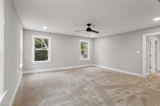 carpeted spare room featuring ceiling fan and a healthy amount of sunlight