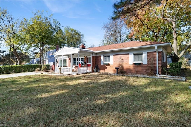 ranch-style home featuring covered porch and a front yard