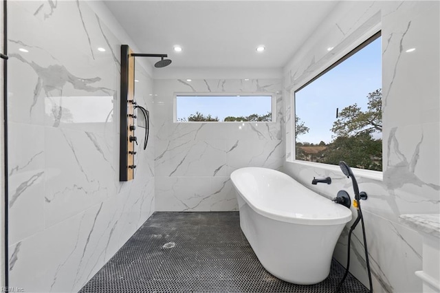 bathroom with plenty of natural light, tile walls, and independent shower and bath