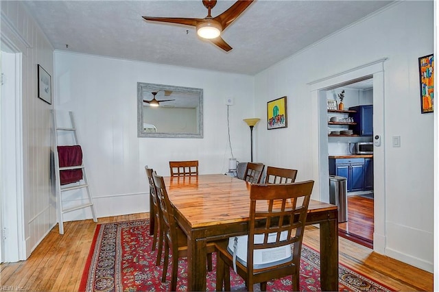 dining space featuring light wood-type flooring, ceiling fan, and ornamental molding