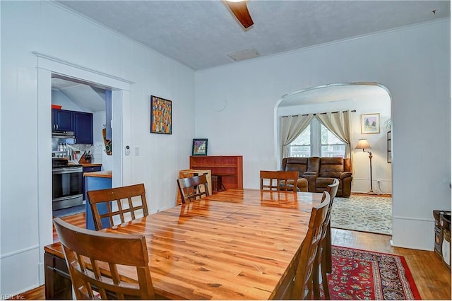 dining space featuring crown molding, hardwood / wood-style floors, ceiling fan, and lofted ceiling