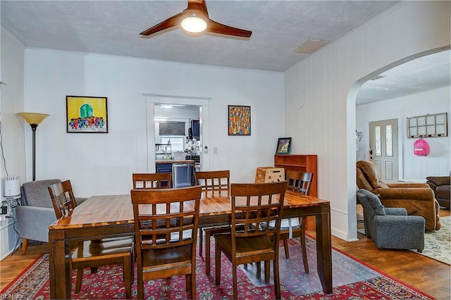 dining space with ceiling fan, crown molding, and hardwood / wood-style flooring