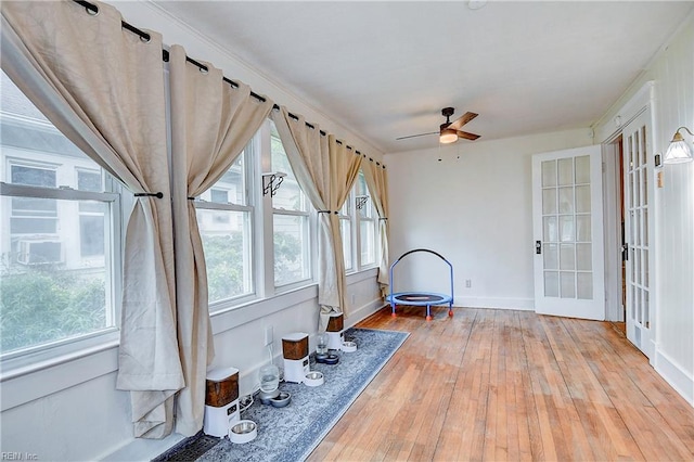 unfurnished sunroom featuring ceiling fan and french doors