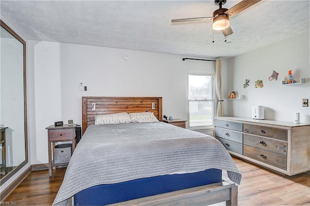 bedroom featuring a textured ceiling, light wood-type flooring, a closet, and ceiling fan