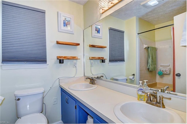 bathroom with a textured ceiling, vanity, toilet, and a shower with curtain