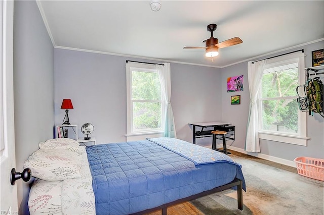 carpeted bedroom with ceiling fan and ornamental molding