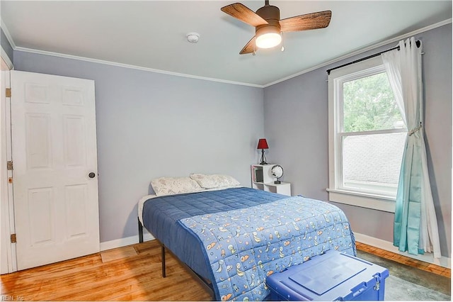 bedroom with hardwood / wood-style flooring, ceiling fan, and crown molding