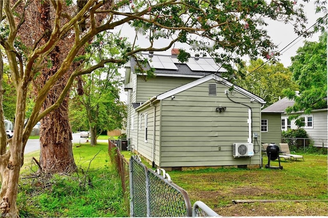 view of home's exterior featuring ac unit, solar panels, and a lawn