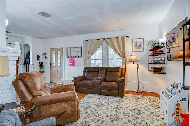 living room with crown molding and light hardwood / wood-style floors