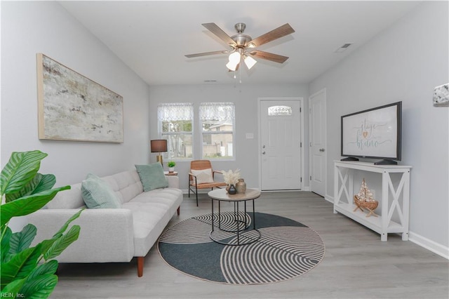 living room with light hardwood / wood-style flooring and ceiling fan