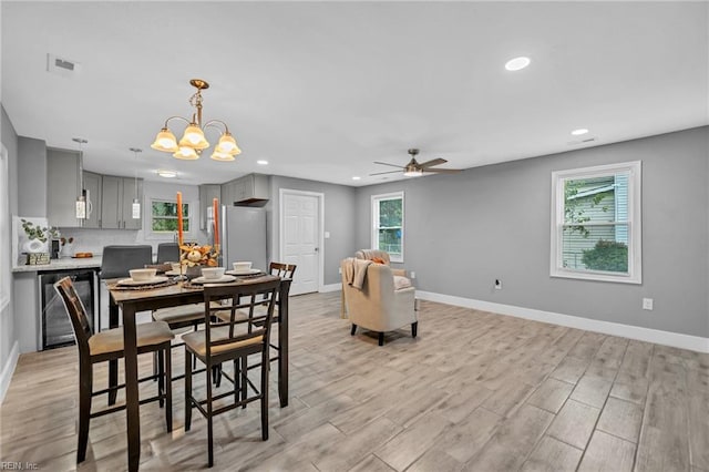 dining room featuring plenty of natural light, beverage cooler, and light hardwood / wood-style flooring