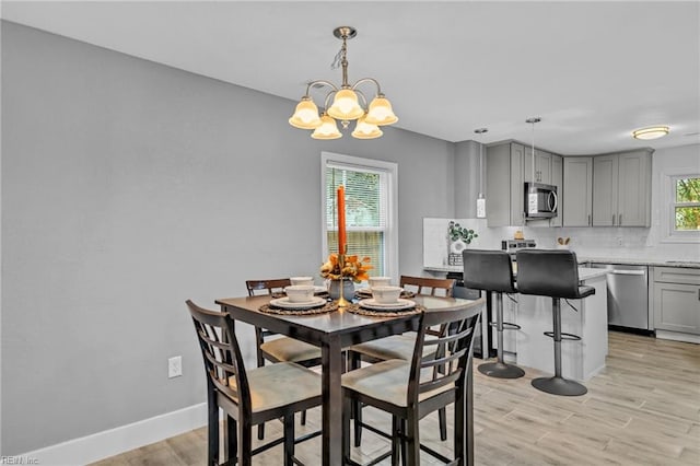 dining area featuring a notable chandelier and light hardwood / wood-style floors