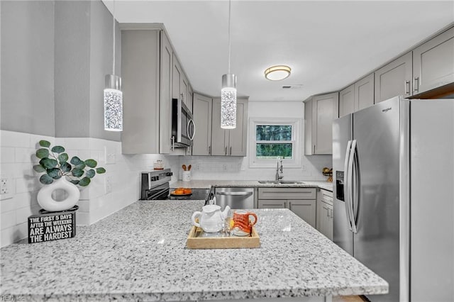 kitchen with decorative backsplash, stainless steel appliances, sink, decorative light fixtures, and gray cabinets