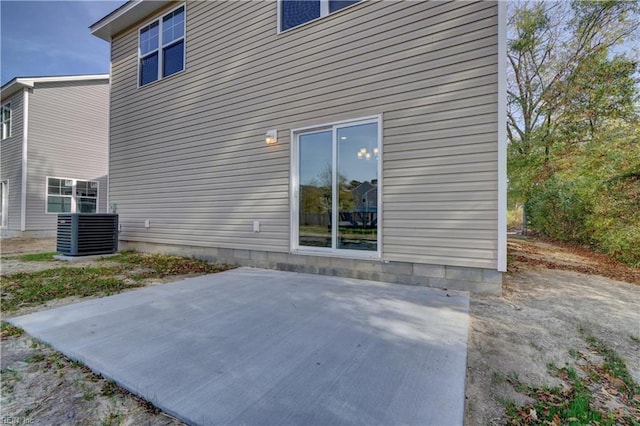 rear view of house with central air condition unit and a patio