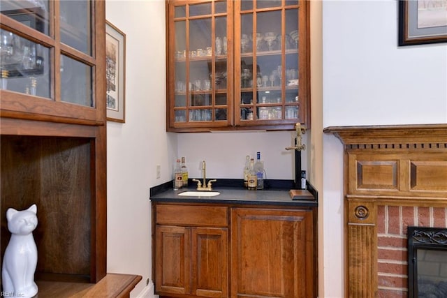 bar featuring sink and a brick fireplace