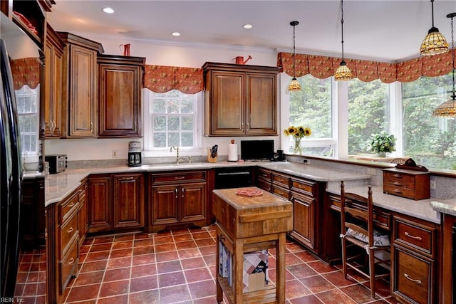 kitchen featuring crown molding, light stone countertops, sink, and hanging light fixtures