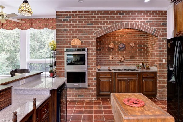 kitchen with appliances with stainless steel finishes, brick wall, beverage cooler, crown molding, and butcher block counters