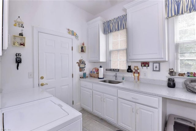 kitchen with white cabinetry, a healthy amount of sunlight, sink, and washer and dryer