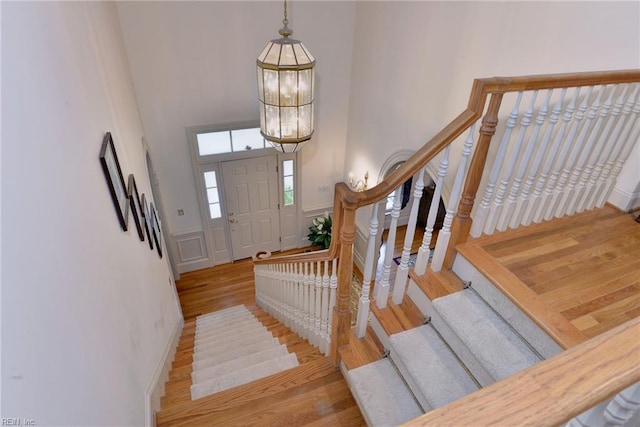 entrance foyer with a chandelier, a high ceiling, and light wood-type flooring