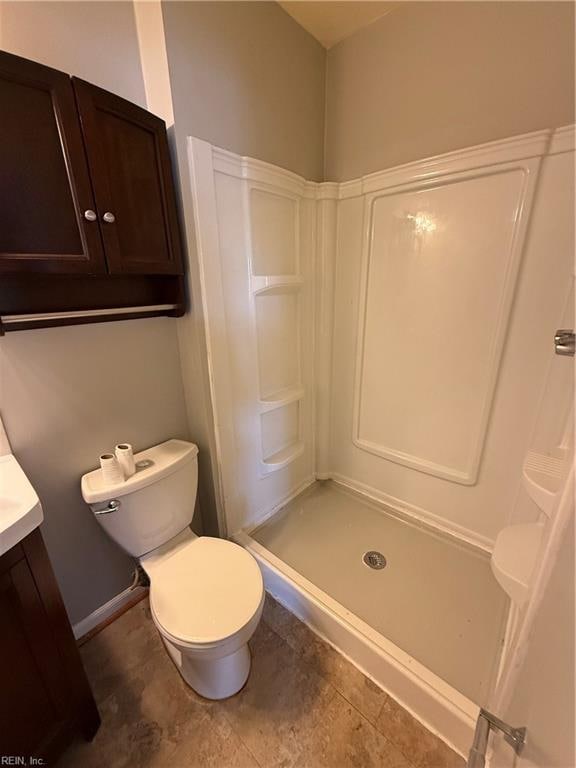 bathroom featuring a shower, vanity, and toilet