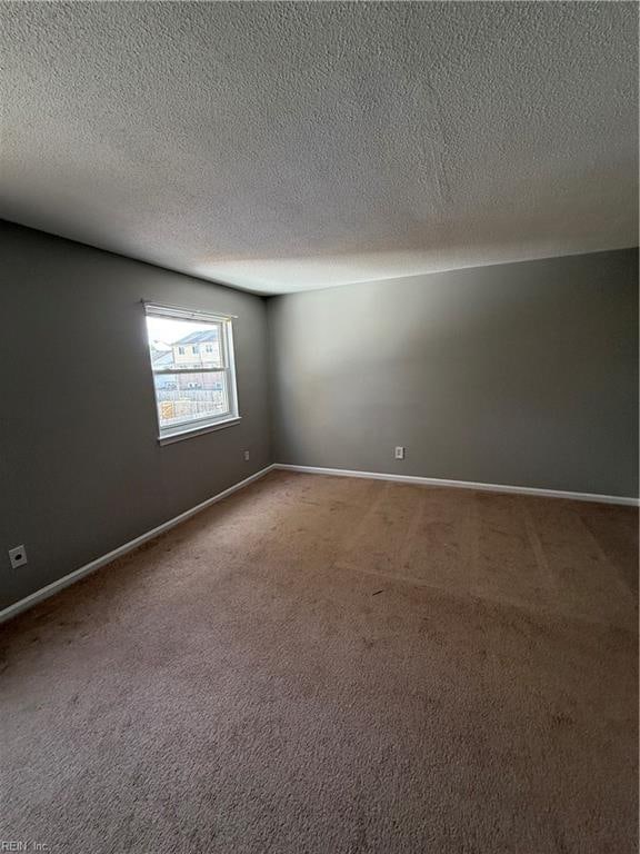 carpeted empty room with a textured ceiling