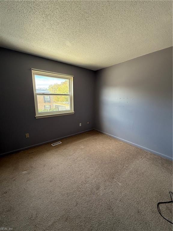 carpeted spare room featuring a textured ceiling