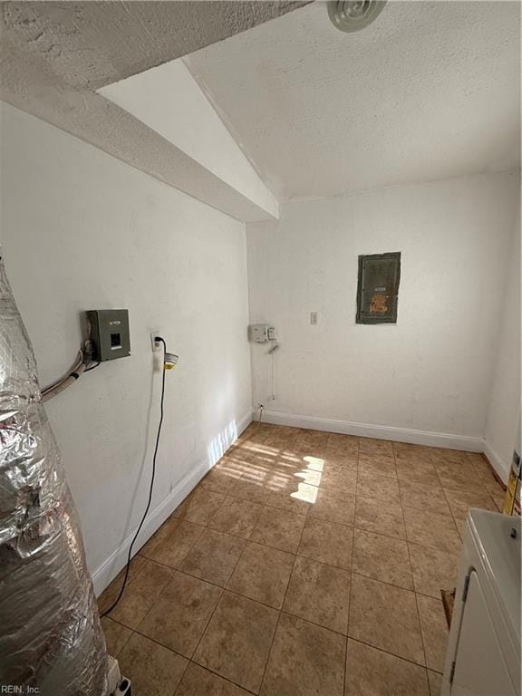 clothes washing area with electric panel and a textured ceiling