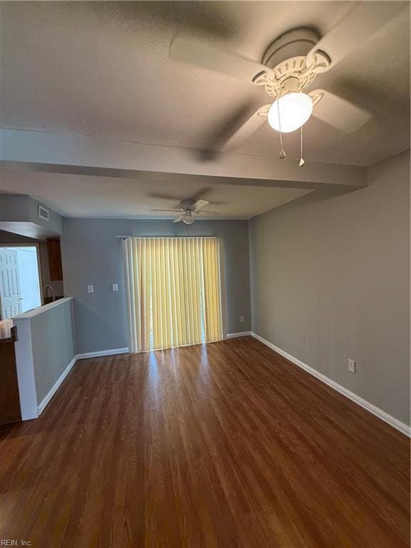 empty room featuring ceiling fan and dark wood-type flooring