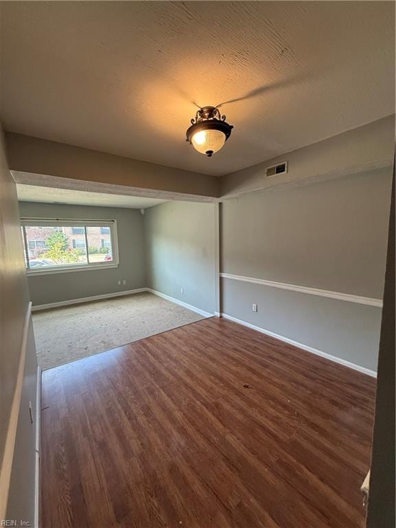 spare room with a textured ceiling and hardwood / wood-style flooring