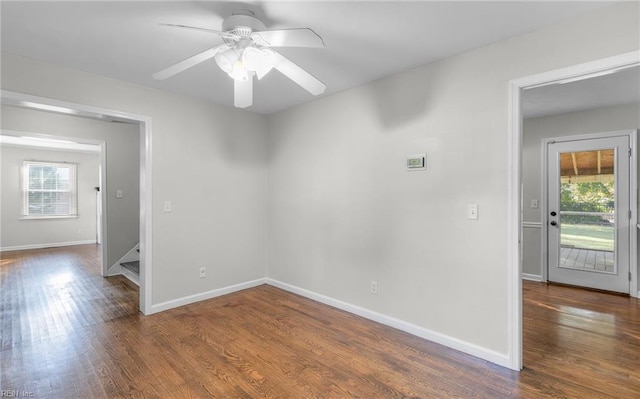 unfurnished room with ceiling fan, dark wood-type flooring, and a wealth of natural light