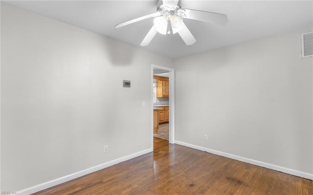 empty room with ceiling fan and dark wood-type flooring