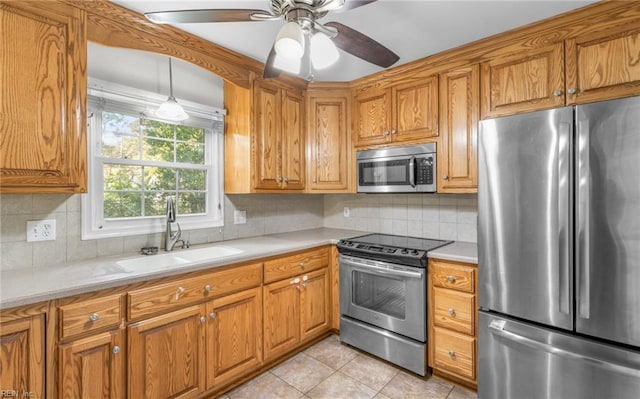 kitchen with decorative light fixtures, stainless steel appliances, tasteful backsplash, and sink