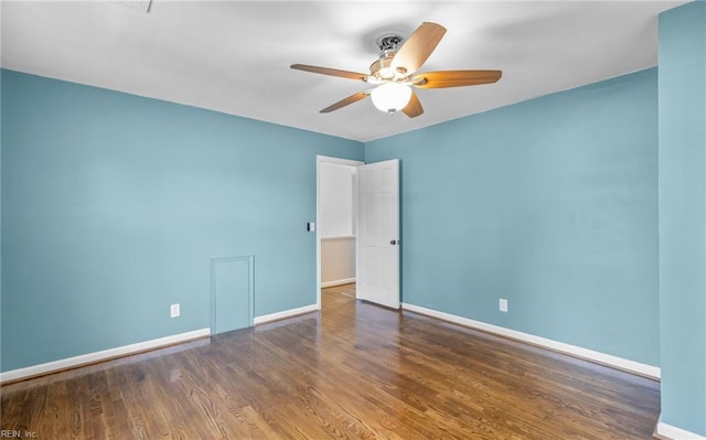 spare room with dark hardwood / wood-style flooring and ceiling fan