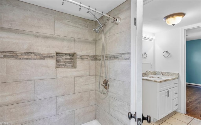 bathroom with vanity, wood-type flooring, and tiled shower