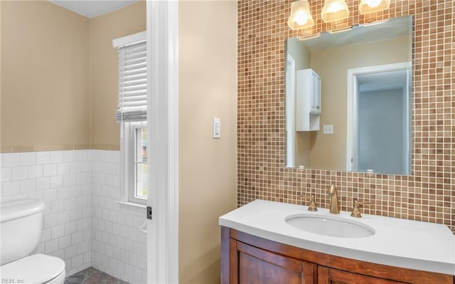 bathroom featuring vanity, a healthy amount of sunlight, and tile walls