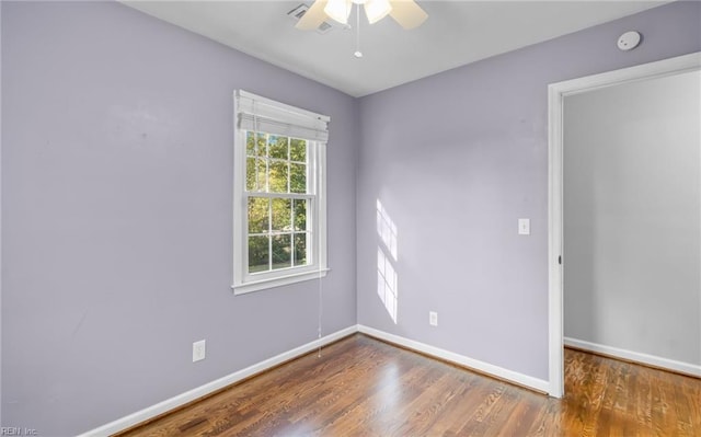 spare room with dark hardwood / wood-style floors and ceiling fan