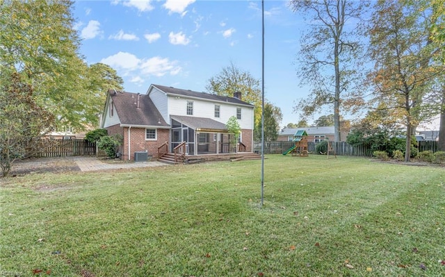 rear view of property with a sunroom, a playground, a lawn, and central air condition unit