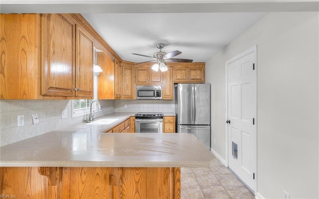 kitchen featuring kitchen peninsula, stainless steel appliances, sink, decorative light fixtures, and light tile patterned flooring