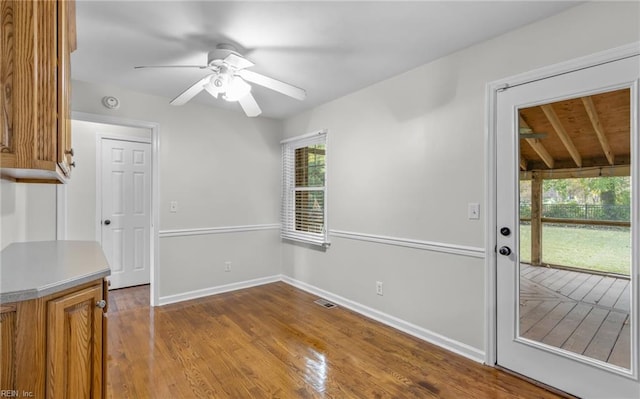 unfurnished dining area featuring beamed ceiling, wood-type flooring, ceiling fan, and wood ceiling