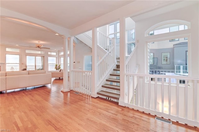 interior space with ornate columns, ceiling fan, vaulted ceiling with beams, and hardwood / wood-style flooring