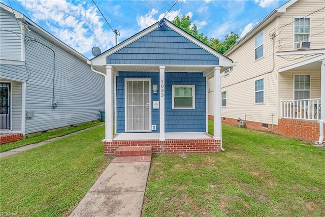 view of front of house with covered porch, cooling unit, and a front yard